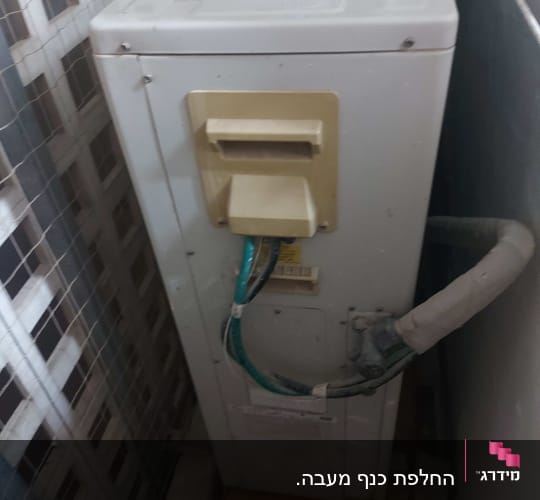 יחידת מזגן חיצונית עם צינורות וחיבורים